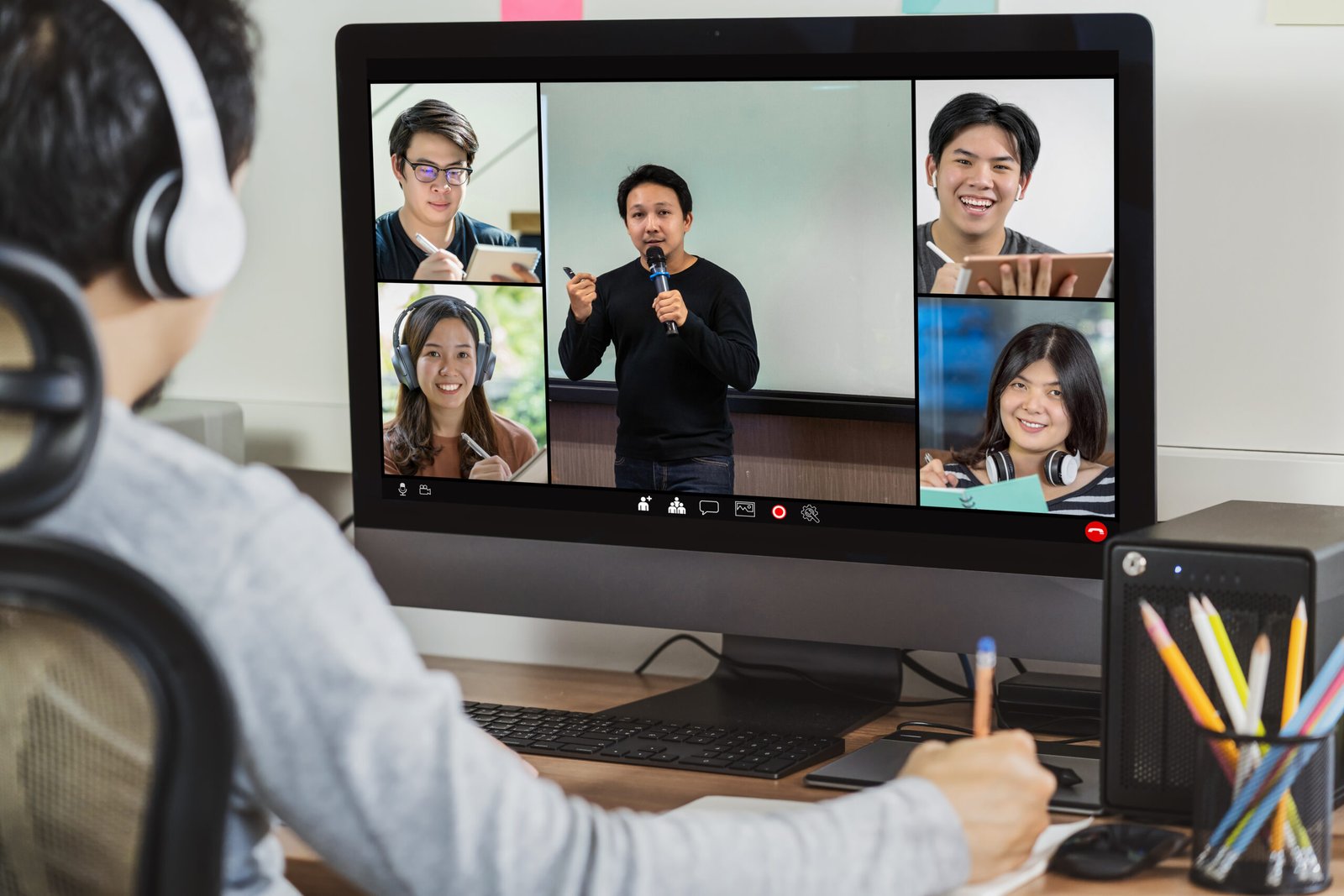 Home rear view of asian businessman working and online meeting via vi